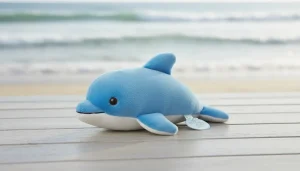 The Petting Zoo dolphin plush toy resting on a soft blue surface.